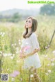 A woman standing in a field of flowers.