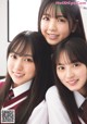 A group of three young women in school uniforms posing for a picture.