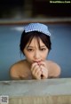 A woman in a blue and white polka dot hat in a pool.